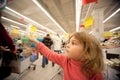 Small girl sit in shoppingcart in supermarket