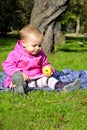 Small girl sits on green glade Royalty Free Stock Photo