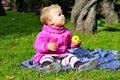 Small girl sits on green glade Royalty Free Stock Photo