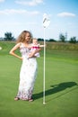 Small girl trying to get the golf ball into Royalty Free Stock Photo