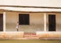 A small girl walks on wall of school in Kenya