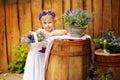 Small girl in white clothes and violet wreath in rustic style decorations. Ecolife. Organic and ecological lifestyle in childhood