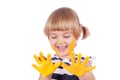 Small girl with yellow paint on her palms