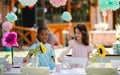 Small girls setting table for summer garden party, birthday celebration concept.