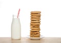 Bottle of milk with straw next to dozen chocolate chip cookies stacked precariously Royalty Free Stock Photo