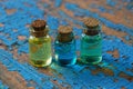 Small glass bottles with colored oils stand on a worn blue table Royalty Free Stock Photo