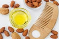 Small glass bowl with almond oil and wooden hair comb for natural hair care. Top view Royalty Free Stock Photo