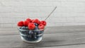 Small glass bowl full of blueberries with raspberries on top, an Royalty Free Stock Photo