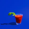 Small glass with cocktail bloody mary  on bright blue neon background. Concept of taste, alcoholic drinks Royalty Free Stock Photo