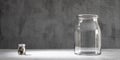 A small glass jar with coins and a large empty one. Start of a new business concept Royalty Free Stock Photo