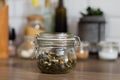 Small glass jar with green tea, healthy breakfast preparation, rustic style interior design, medical herb, blurry background,