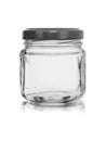 Small glass jar with a metal cover on a white background with reflection Royalty Free Stock Photo