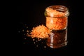 Small glass jar with pile orange organic sea salt Royalty Free Stock Photo