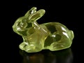small glass rabbit figurine, chartreuse, dark background Royalty Free Stock Photo