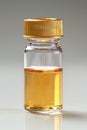 Small glass vial with golden liquid and cap. Transparent bottle with yellow cap filled with amber fluid. Concept of Royalty Free Stock Photo