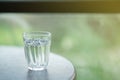 A small glass of water filled with water placed on the table