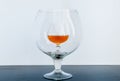 Small glass with whiskey inside big glass on black table Royalty Free Stock Photo