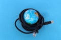 A small globe lies on a blue background surrounded by wires. Royalty Free Stock Photo