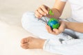 A small globe with trees in the hands of a child. Layout of the planet made of plasticine in children`s palms. Concept Royalty Free Stock Photo