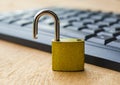 A small golden padlock standing open on a computer keyboard symbolizing cybersecurity breach, data protection risk or online Royalty Free Stock Photo