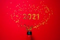 Small golden stars in the form of number 2021 a bottle of champagne on red background. Christmas, Xmas and New Year celebration, Royalty Free Stock Photo