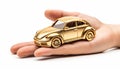 Small golden toy car on the palm of your hand on a black background. Concept of car insurance, guarantee and protection Royalty Free Stock Photo