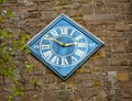 Small Gothic church clock on stone wall of ancient church