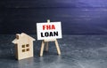 Small gouse and FHA loan easel sign. High risk of default. Mortgage insured by Federal Housing Administration Loan. An affordable Royalty Free Stock Photo