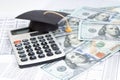 Small graduation cap on calculator, assorted cash Royalty Free Stock Photo