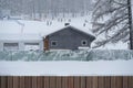 Small Gray Colored Wooden Hut Near the Ski Slopes on a Heavy Snow Day Royalty Free Stock Photo