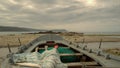 A small gray fishing boat stranded on the sand of a beach on the Galician coast (Spain