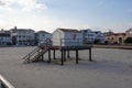 A small gray lifeguard shack on New Haven Avenue on a platform raised above the sand on wooden pilings