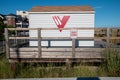 Small gray lifeguard station shack on wooden platform surrounded by tall grass plants with the Ventnor City lifeguard logo Royalty Free Stock Photo