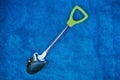 Small gray metal shovel toy on blue wool Royalty Free Stock Photo