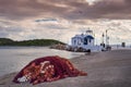 A small greek chapel over sea and small bay under a dramatic sky Royalty Free Stock Photo