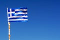 A small Greek flag waving in the wind against the blue sky Royalty Free Stock Photo