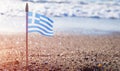 Small Greek waving flag flying over sea water Royalty Free Stock Photo