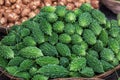 Small green bitter gourds are kept in baskets for sale in the market. Fresh Bitter melon vegetable on the basket. Close-up view Royalty Free Stock Photo