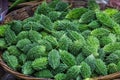 Small green bitter gourds are kept in baskets for sale in the market. Fresh Bitter melon vegetable on the basket. Close-up view Royalty Free Stock Photo