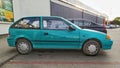 Old green compact car Suzuki Swift GLS parked