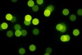 Small green bokeh of light on dark black background wallpaper