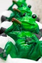 Ceramic green frog in a frivolous pose