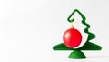 A small green Christmas tree with a hanging red ball on a white background Royalty Free Stock Photo