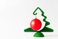 A small green Christmas tree with a hanging red ball on a white background, banner, copy space. Royalty Free Stock Photo