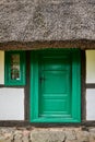 A small green door and window in an old thatched house Royalty Free Stock Photo