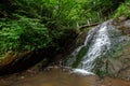 Small green forest waterfall in the cave mountains, cascades on a mountain river. The concept of active holidays, holidays Royalty Free Stock Photo