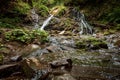 Small green forest waterfall in the cave mountains, cascades on a mountain river. The concept of active holidays, holidays Royalty Free Stock Photo