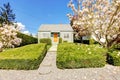 Small green house exterior with spring blooming trees. Royalty Free Stock Photo