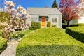 Small green house exterior with spring blooming trees. Royalty Free Stock Photo