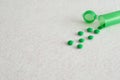Small green pills with a little green pill bottle Royalty Free Stock Photo